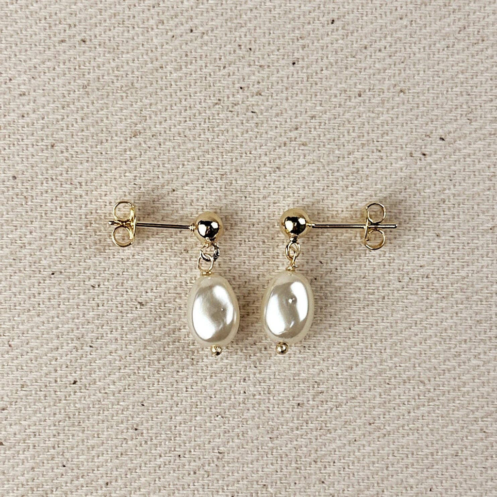 Simulated baroque pearl drop earrings with gold ball studs on linen