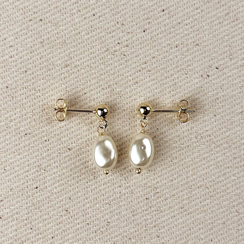 Simulated baroque pearl drop earrings with gold ball studs on linen