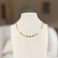 Gold leaf charm chain necklace on a linen bust