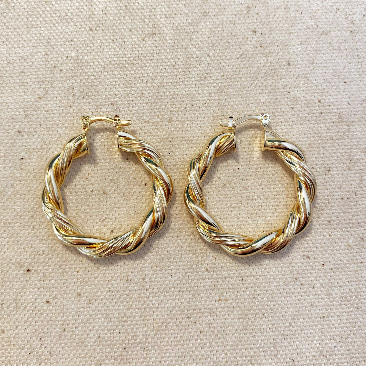 Gold filled twisted tube hoop earrings on linen