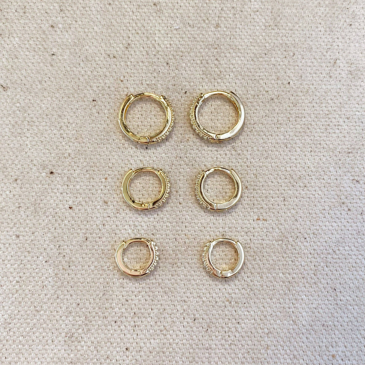 Pavé hoop earring trio in three sizes laid out on linen