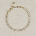 Gold filled baguette tennis bracelet with extender chain on linen