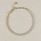 Gold filled baguette tennis bracelet with extender chain on linen