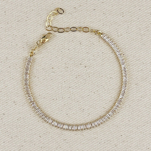 Gold filled baguette tennis bracelet with extender chain on linen