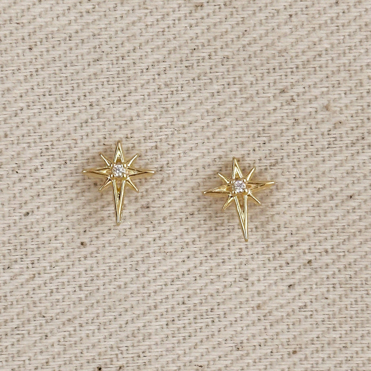 Gold filled starburst stud earrings on linen