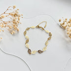 Gold filled leaf charm chain bracelet laid flat with dried flowers