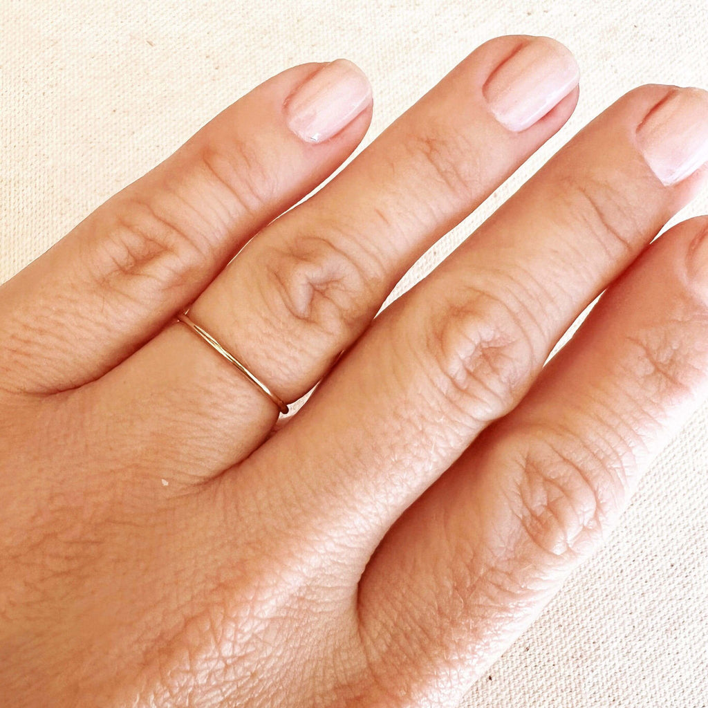 Plain gold stacking ring worn on the finger