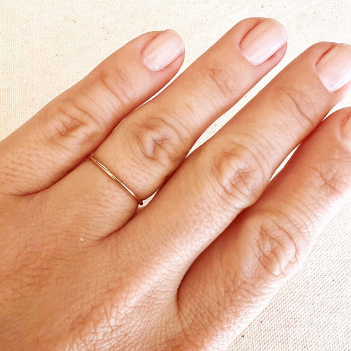 Plain gold stacking ring worn on the finger