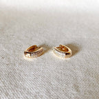 Gold oval pavé hoops on linen
