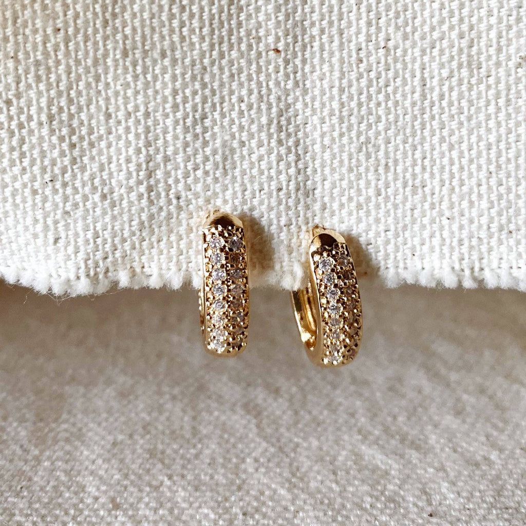 Pavé oval huggie hoops hanging on linen
