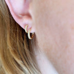 Pavé huggie hoops stacked on the ear