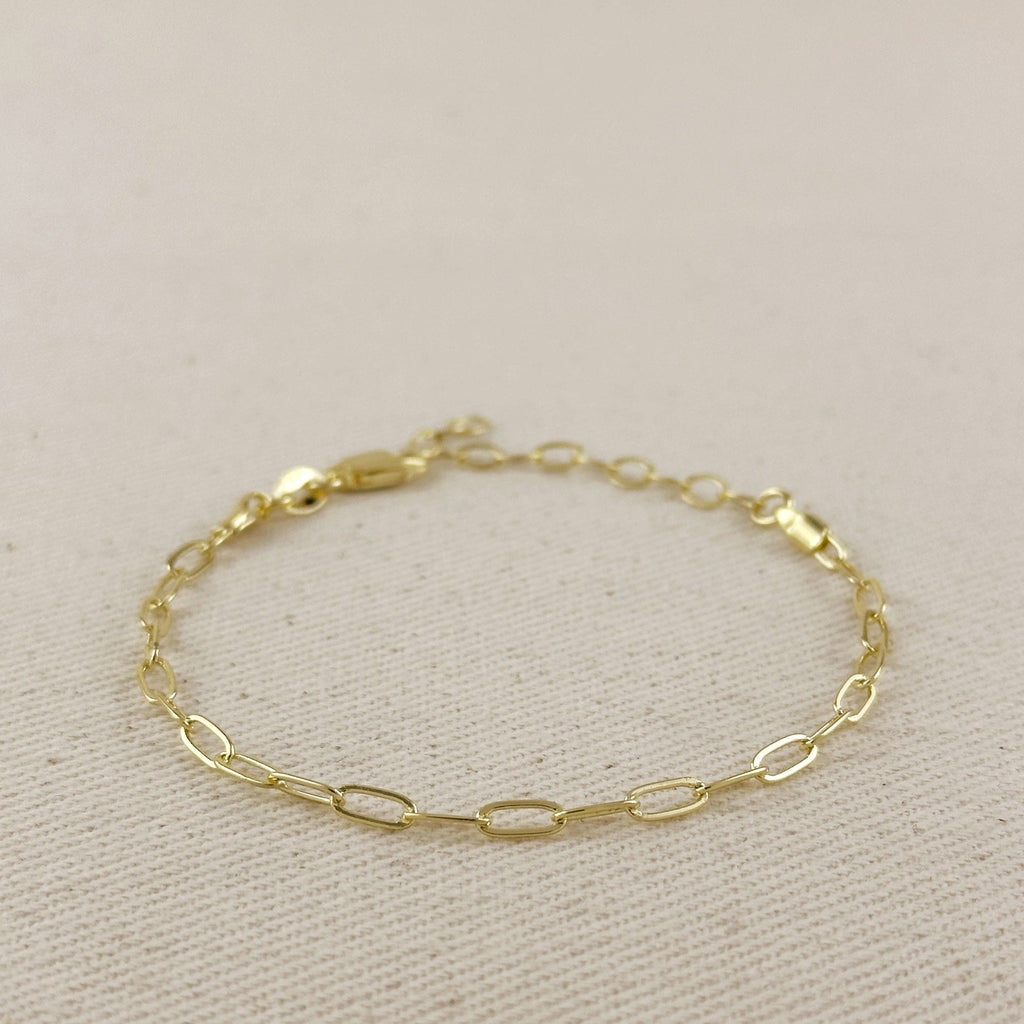 Gold paperclip bracelet with clasp on linen