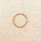 Thin gold filled band ring on linen