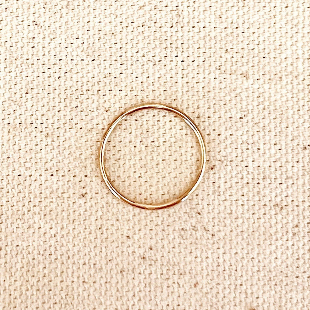 Thin gold filled band ring on linen
