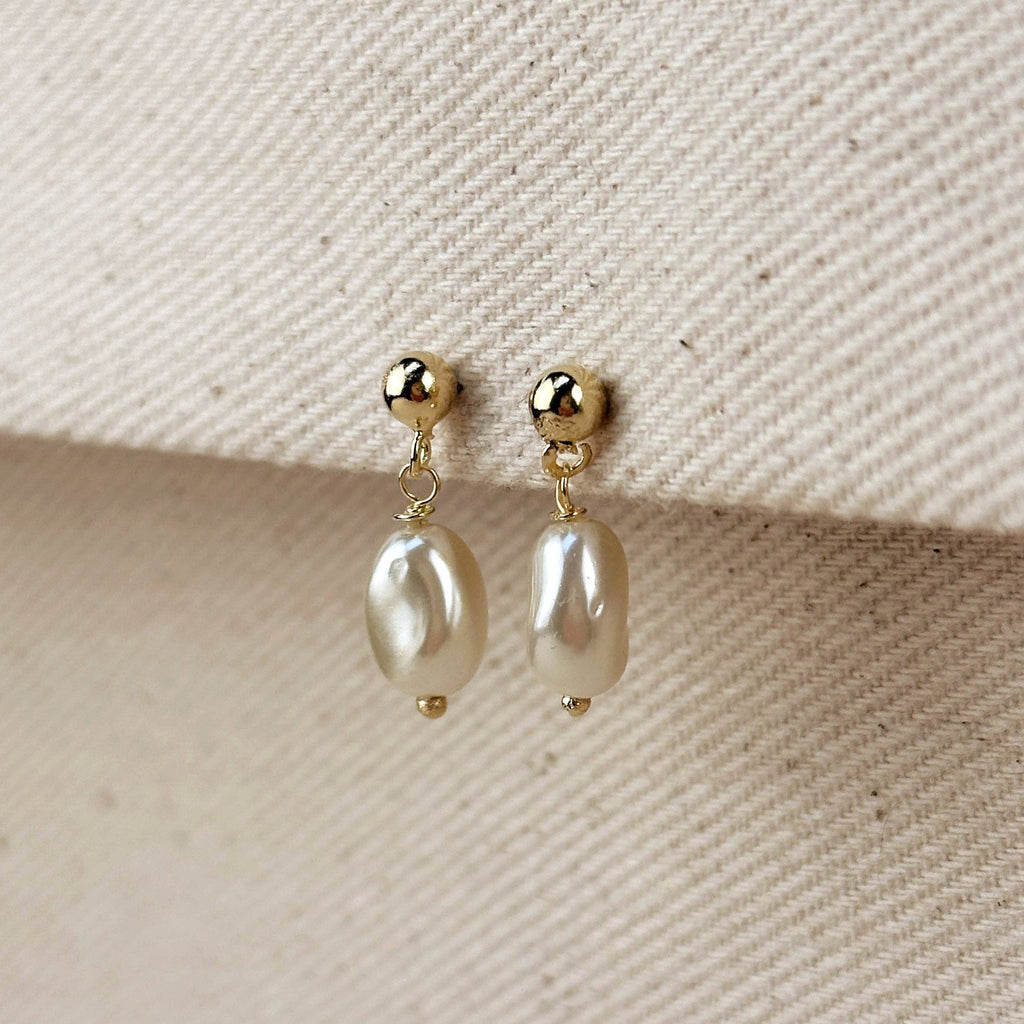 Gold filled pearl drop earrings on a linen edge