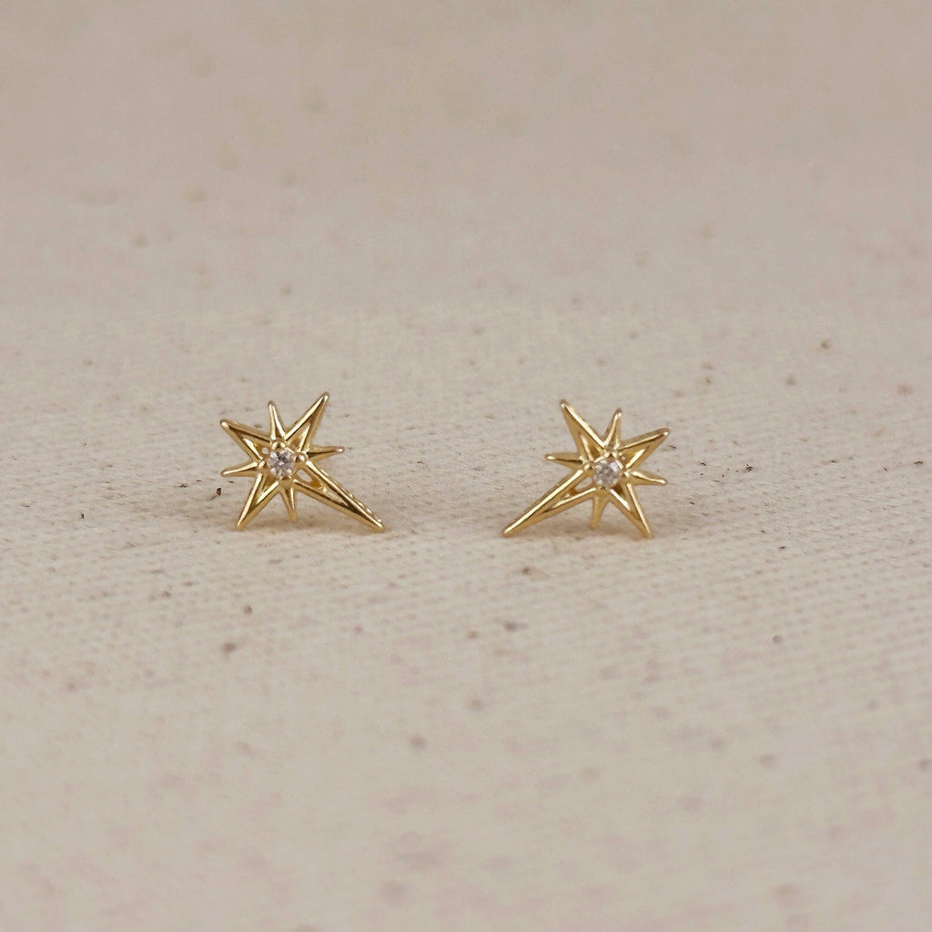 Pair of gold starburst studs on linen