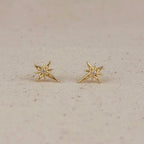 Pair of gold starburst studs on linen