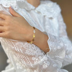 Leaf charm chain bracelet worn on the wrist with white lace