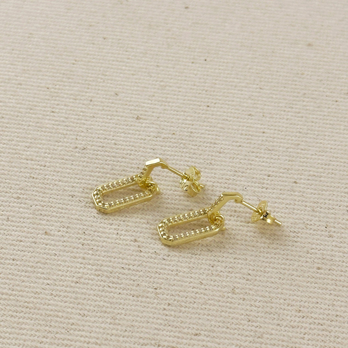 Gold filled link drop earrings laid flat on linen