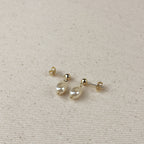 Pair of baroque pearl drop earrings on linen