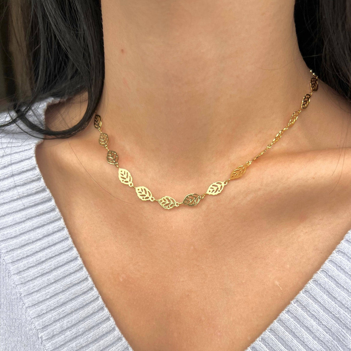 Gold leaf chain necklace styled with a grey knit