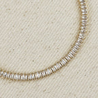 Close up of baguette-cut stones on a gold tennis bracelet