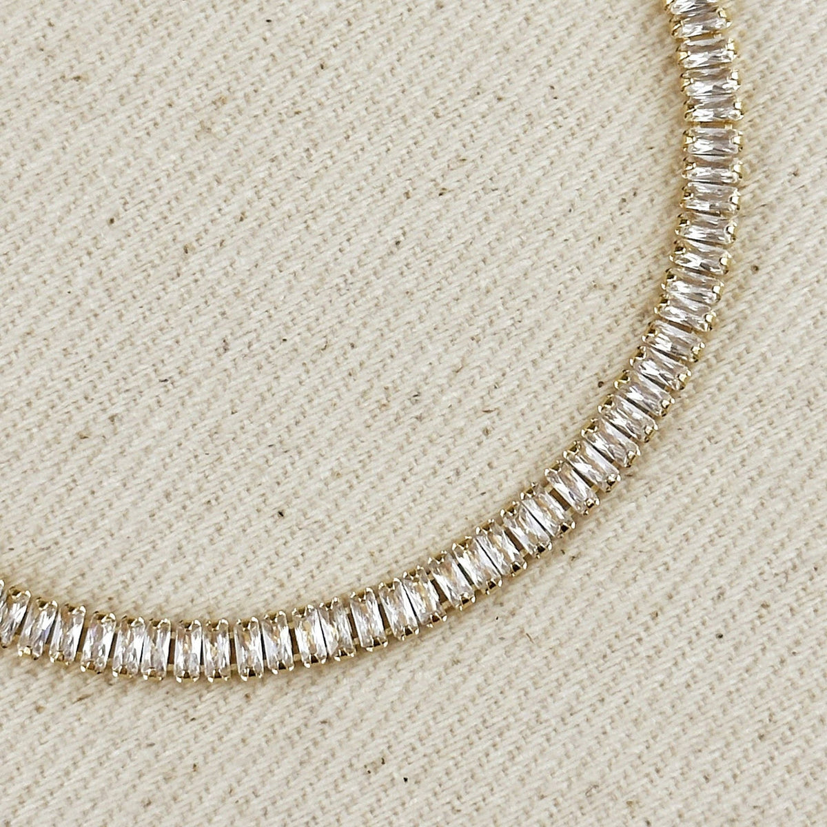 Close up of baguette-cut stones on a gold tennis bracelet