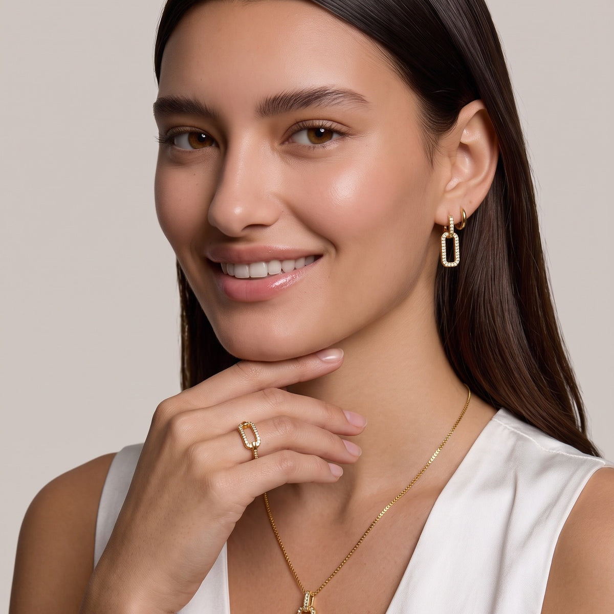 Model wearing gold pavé link drop earrings