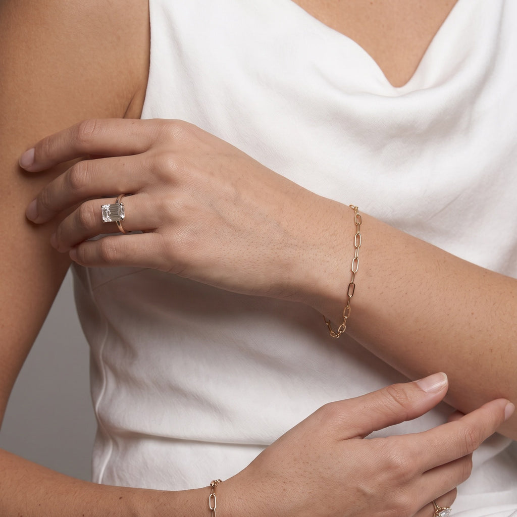 Gold paperclip chain bracelet styled with a white top