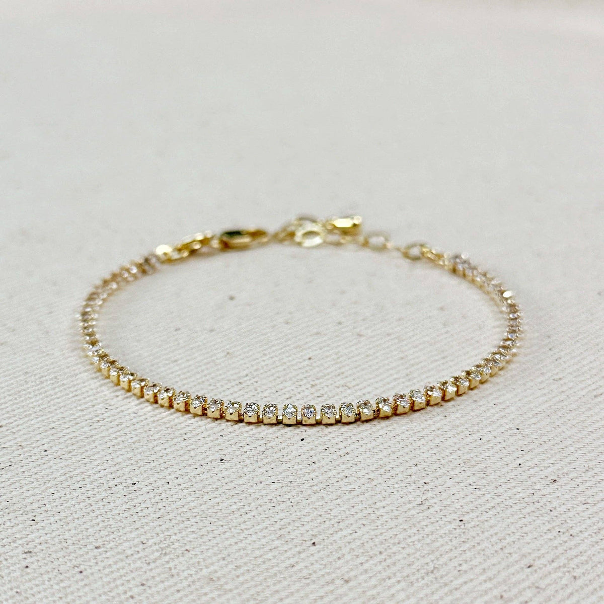 Gold marquise cubic zirconia tennis bracelet on linen