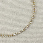 Close up of marquise-cut stones on a gold tennis necklace
