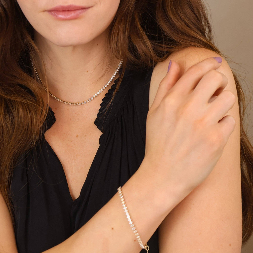 Model wearing a gold tennis necklace and tennis bracelet