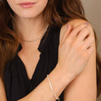 Model wearing a gold tennis necklace and tennis bracelet