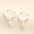 Silver huggie hoop earrings with tiny crystal star charms