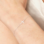 Sterling silver cross bracelet worn on the wrist