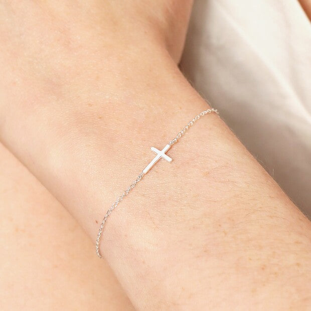 Sterling silver cross bracelet worn on the wrist