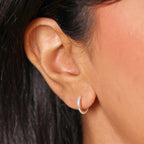 Sterling silver huggie hoop worn on the ear lobe